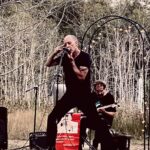 vocalist and guitarist perform outdoors