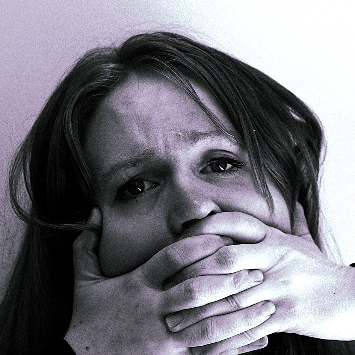 Closeup of woman looking upset with her hands covering her mouth