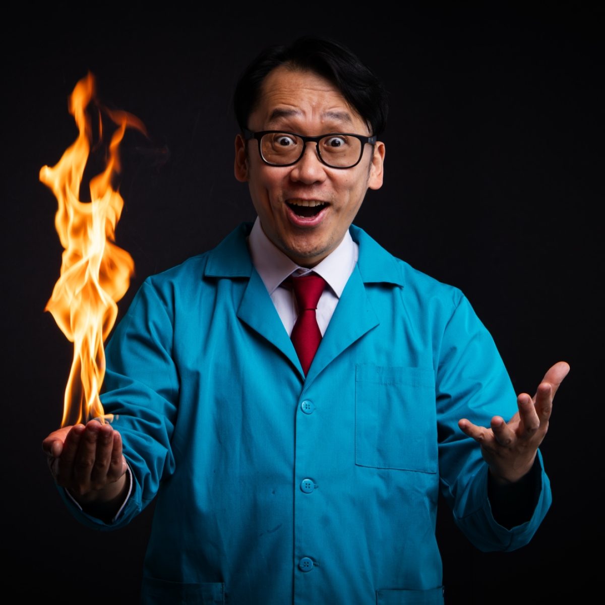 Man with happy surprised expression has large flames in the palm of one hand