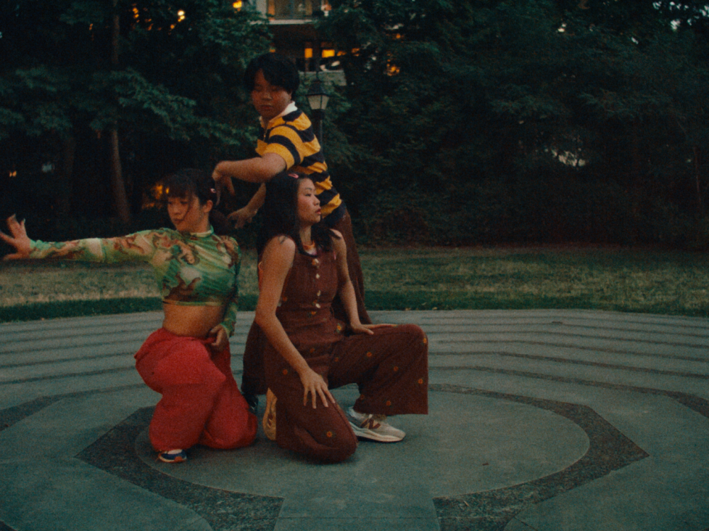 3 crouched dancers on a circular plaza